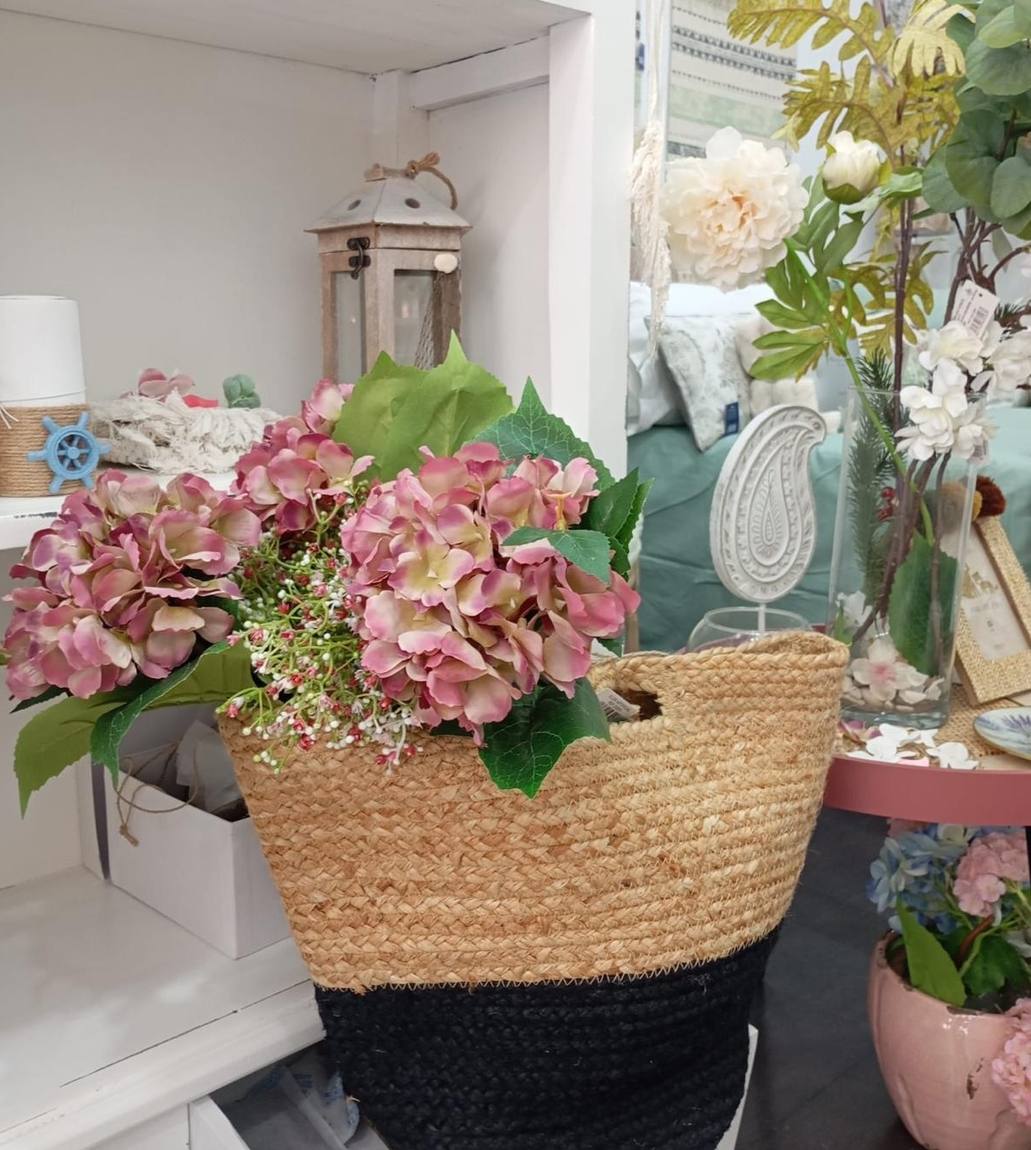 Cesta de yute con un arreglo de hortensias montado encima