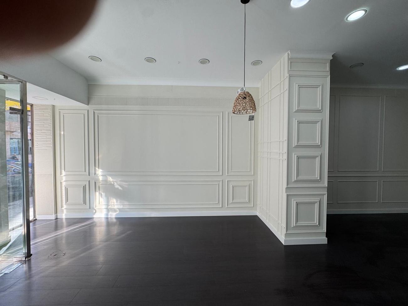 Salón con paneles decorativos a dos alturas y friso ranurado bajo el techo
