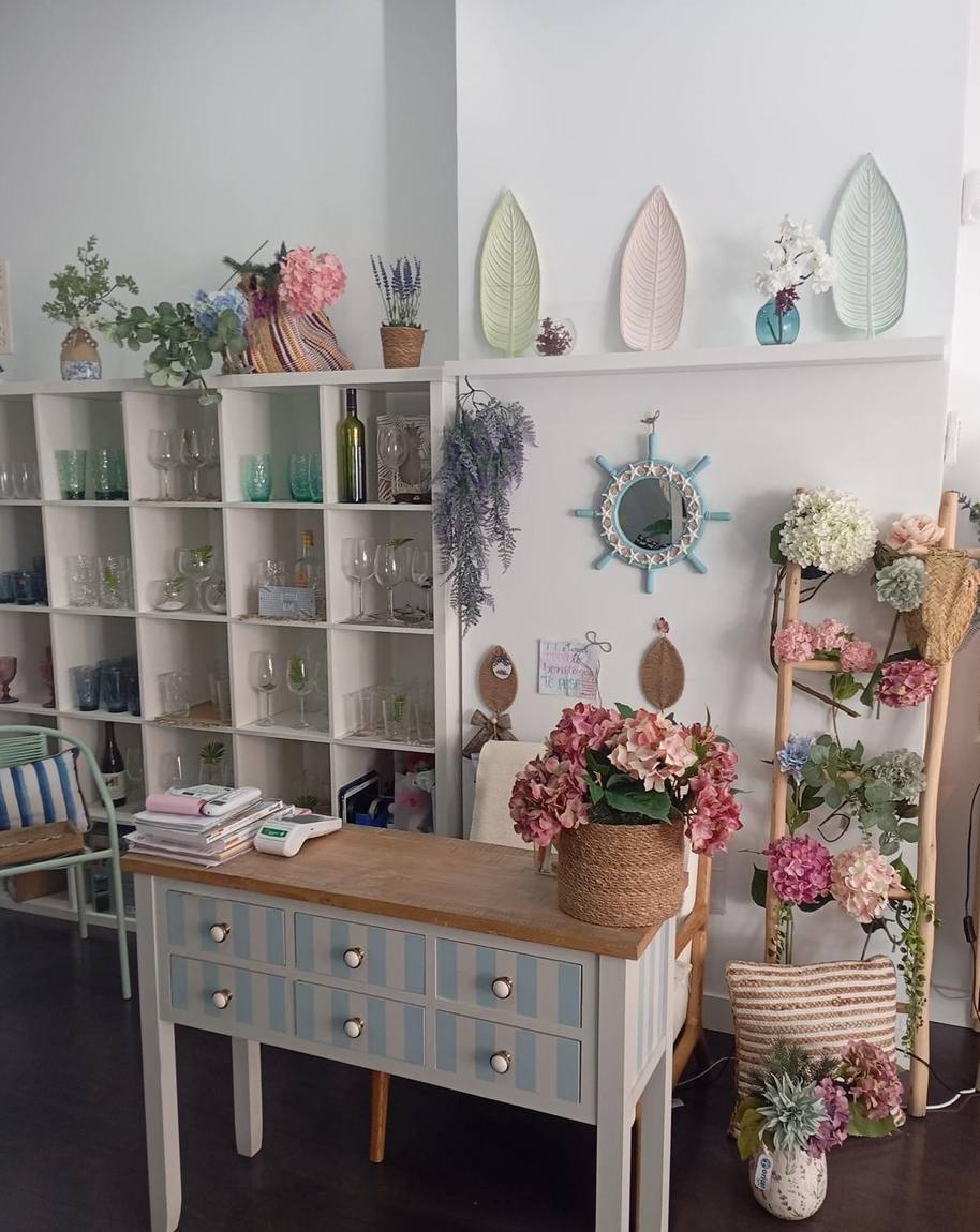 Mostrador de la tienda con piezas de vajilla y flores preparadas
